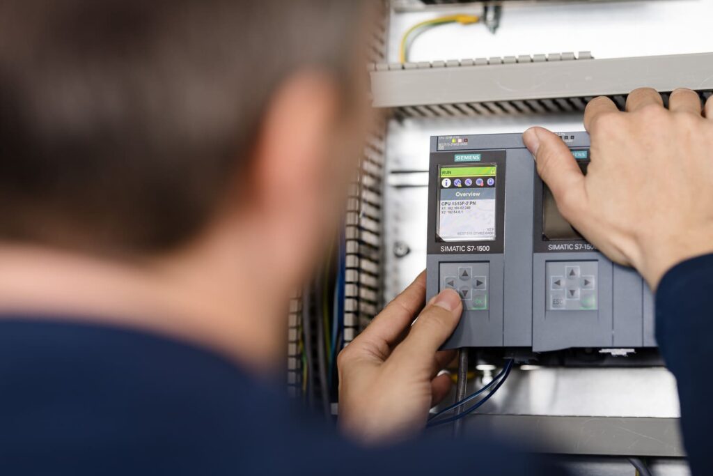 Techniker bedient eine Siemens SIMATIC S7-1500 im Schaltschrank
